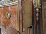 a very ornate chest of drawers with a marble top