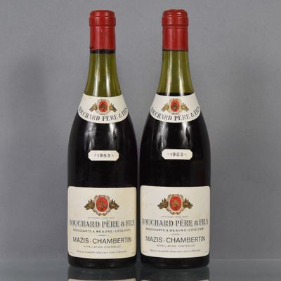 two bottles of red wine sit on a table next to each other