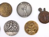 six different types of medals are displayed on a white surface