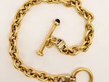 a close up of a gold chain with a key on it