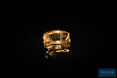 une bague sertie d'un saphir jaune sur fond noir