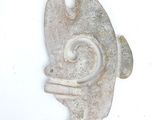 a stone sculpture of a fish on a white surface