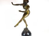 bronze statue of a woman holding a tennis racquet on a black base