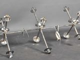 four metal objects are arranged in a row on a gray surface