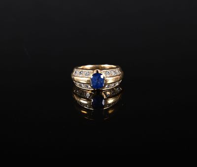 une bague en or sertie d'un saphir et de diamants sur un fond noir