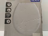 une boîte en carton posée sur une table, sur laquelle se trouve un couvercle de WC blanc