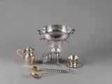 une coupe en argent et d'autres objets en argent posés sur une table