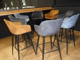 four stools that are sitting in front of a bar