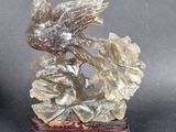 a statue of a bird sitting on top of a flower