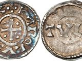 a close up of a silver coin with a cross on it
