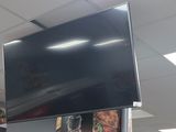 a large flat screen tv hanging from the ceiling in a restaurant