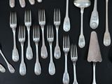 many forks and spoons laid out on a table
