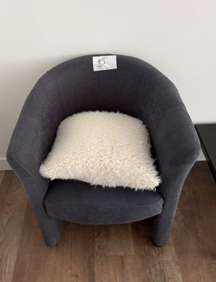 une petite chaise sur laquelle est posé un coussin, dans une pièce