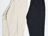 deux paires de pantalons noirs et blancs posés sur une surface blanche