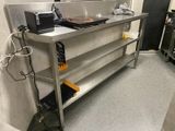 stainless steel work table with a laptop on top of it in a kitchen