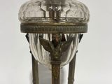 an antique brass and glass table lamp with a bird on the top