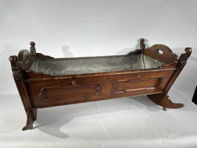 un vieux berceau en bois surmonté d'un plateau en métal