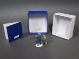 a small figurine of a man standing in a box