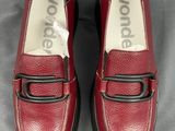mocassins rouges avec des boucles noires sur une surface grise