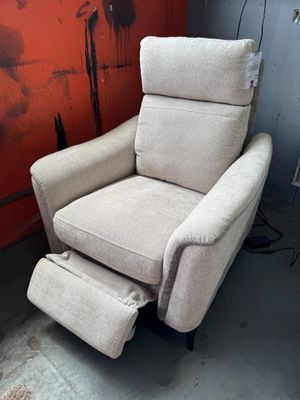 Le fauteuil inclinable se trouve dans un coin de la pièce, avec un mur rouge en arrière-plan