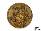 une pièce d'or ornée d'un oiseau sur une surface blanche
