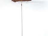 une sculpture représentant une feuille, posée sur un socle, sur une surface blanche