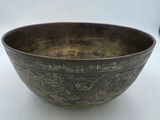 a close up of a metal bowl on a white surface