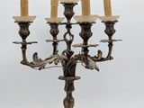 an antique brass candelab with five candles and a bird on it