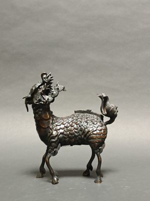 bronze statue of a goat with a bird on its back