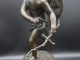 an image of a statue of a cupid holding a tennis racquet
