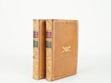 un vieux livre posé sur une table blanche à côté d'un livre