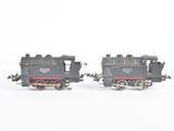 two toy trains sitting side by side on a white surface