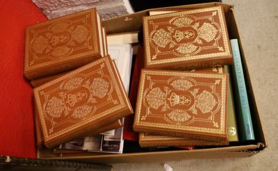 quatre livres dans une boîte posée par terre, les uns à côté des autres