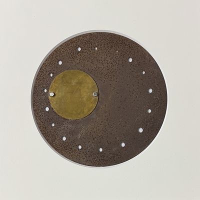a brown plate with a gold disc on it