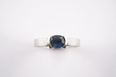 un gros plan d'une bague sertie d'un saphir bleu sur fond blanc