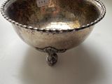 a silver bowl with a bird on it on a table