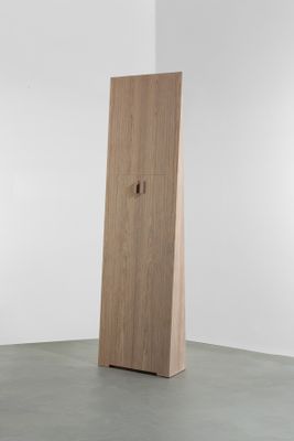 une photo d'une grande armoire en bois dans une pièce blanche