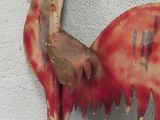 a red bird on the wall with a knife in it ' s mouth