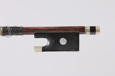 gros plan d'un archet de violon sur fond blanc