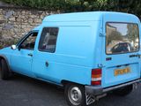a blue van that is parked on the side of the road