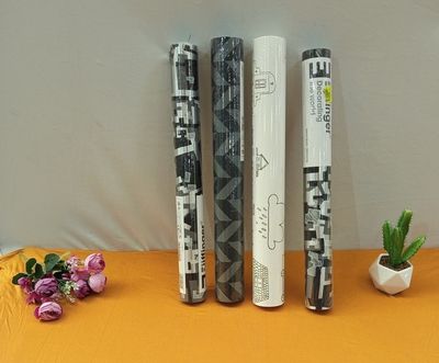 three rolls of wrapping paper sitting on a table next to flowers