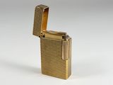 a gold plated lighter sitting on top of a white surface