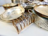 beaucoup d'assiettes et de bols en argent posés sur une table