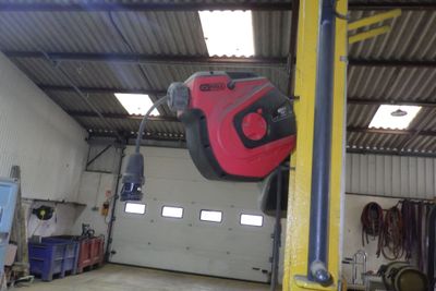 un objet rouge et noir suspendu à un poteau dans un garage