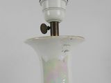 a white vase that has a light on top of it