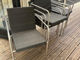 three chairs sitting on a wooden deck next to a glass door