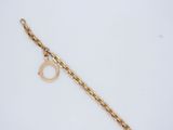 a close up of a gold chain bracelet with a ring on it