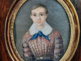portrait d'un jeune garçon vêtu d'une robe rouge et blanche ornée d'un nœud bleu