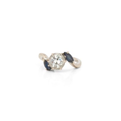 a close up of a diamond and sapphire ring on a white background