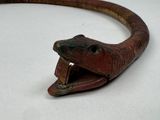 a snake that is sitting on a table with its mouth open